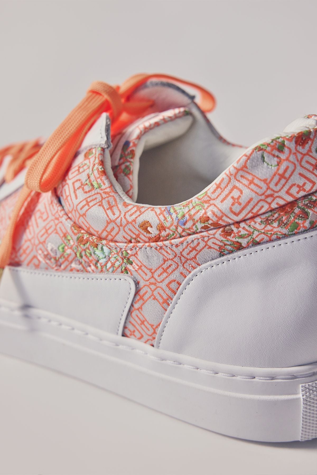 Low-cut sneakers with orange shoelaces