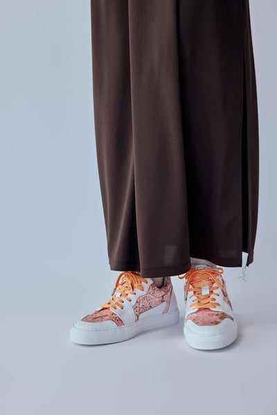 Low-cut sneakers with orange shoelaces